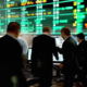 Create an image depicting a futuristic stock exchange floor bustling with activity, where digital screens prominently display bitcoin symbols and charts. Traders are animatedly discussing and analyzin